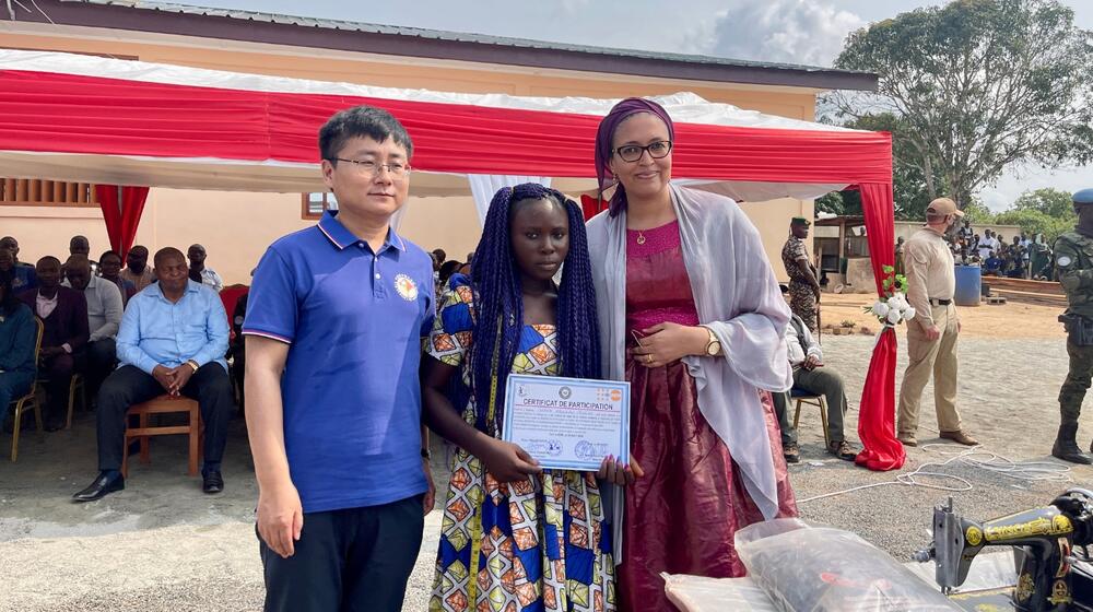 La Directrice des Opérations de l'UNFPA RCA, Madame Chada Mohamed et le Chargé d'Affaires de l'Ambassade de la République Populaire de Chine en RCA remettent un certificat de fin de formation à l'une des bénéficiaires. Crédit photo : UNFPA RCA/Jean-Philip Lawson